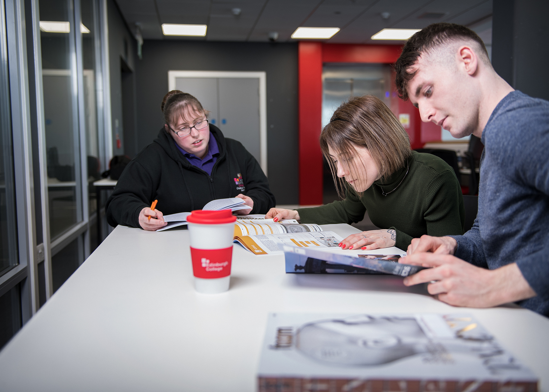 Three students looking through the college prospectus, and planning their career options.