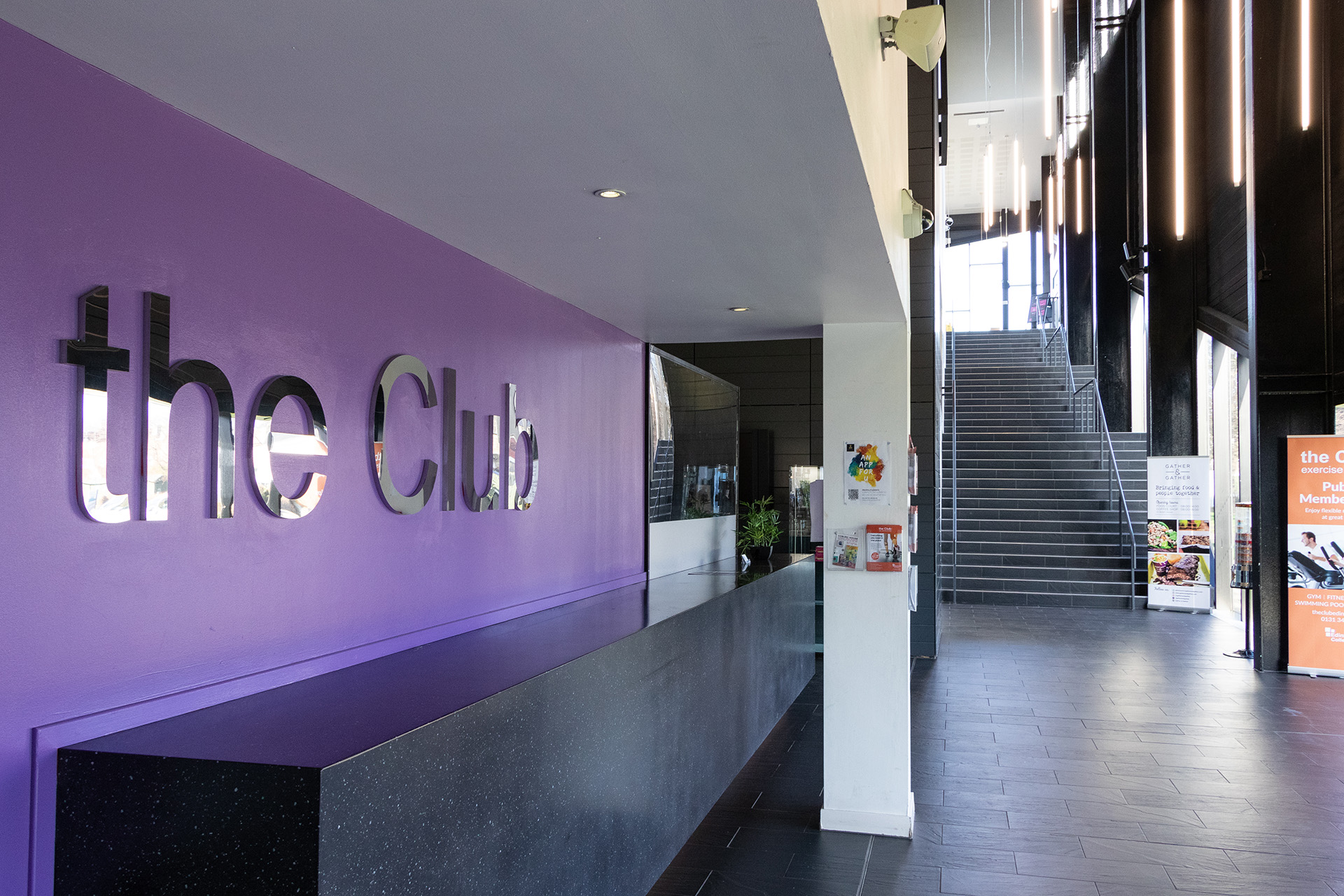 Entrance of the Club gym with a sign on the purple wall that reads 'The Club'