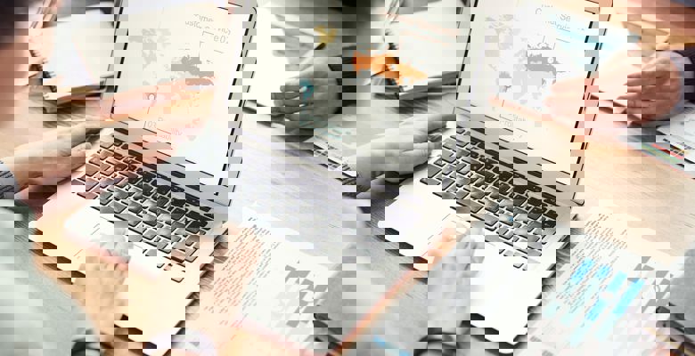 Person looking at world map on their laptop screen.