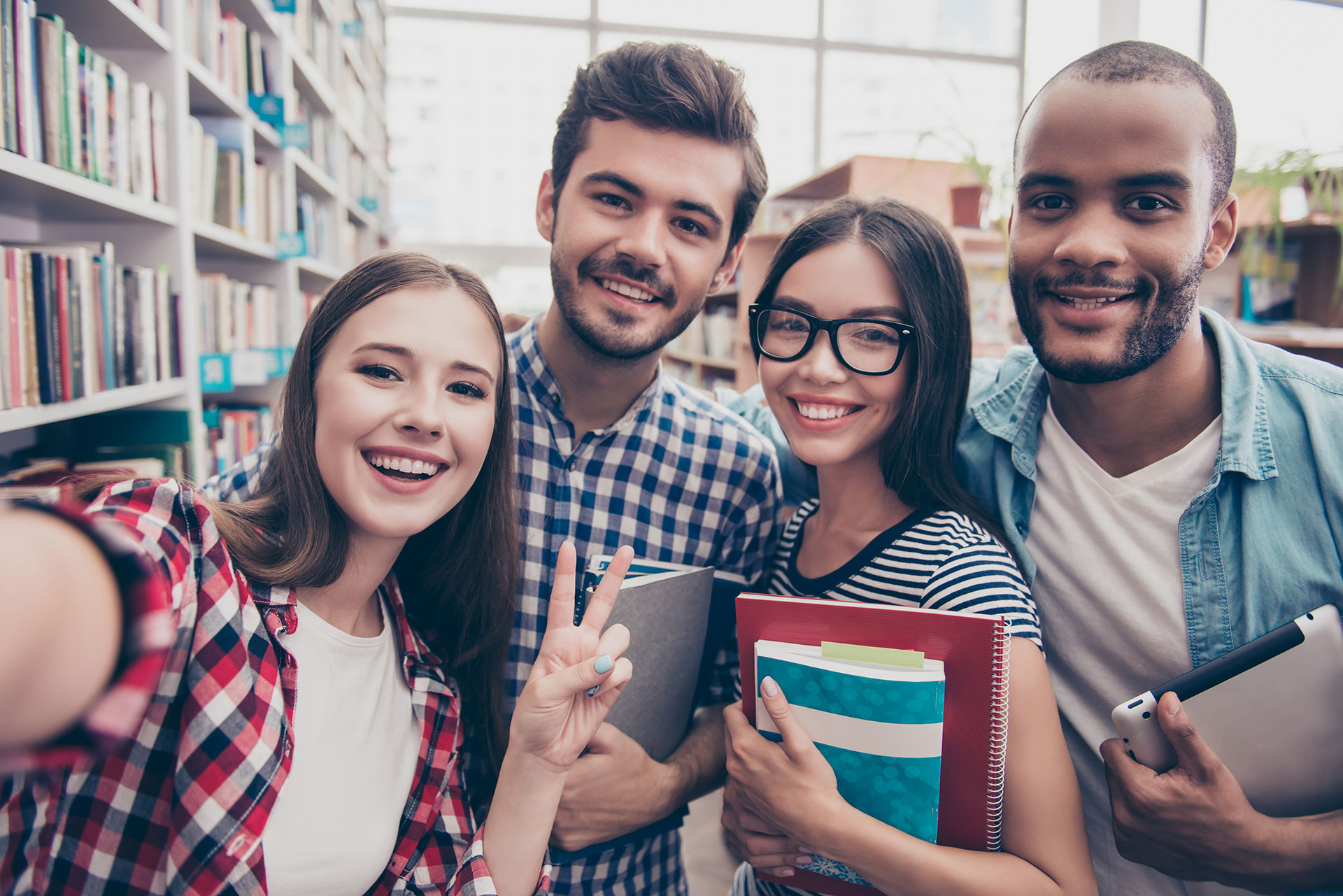 Selfie of students smiling in the library. 