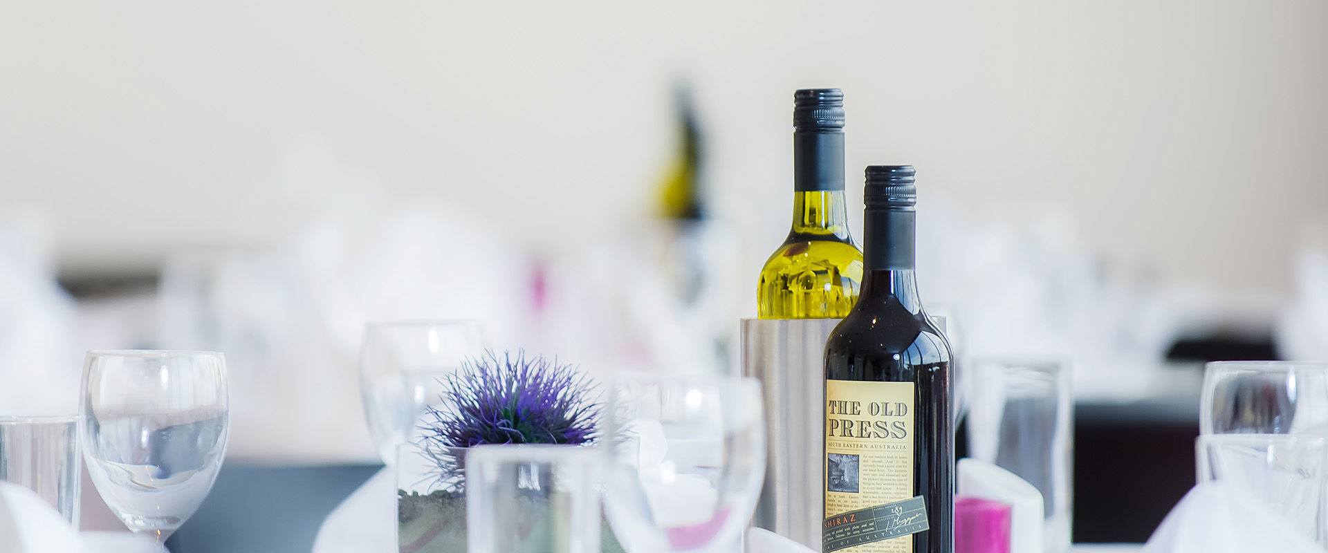 Table setting at EH15 restaurant, with flowers, wine glasses and a bottle of wine.