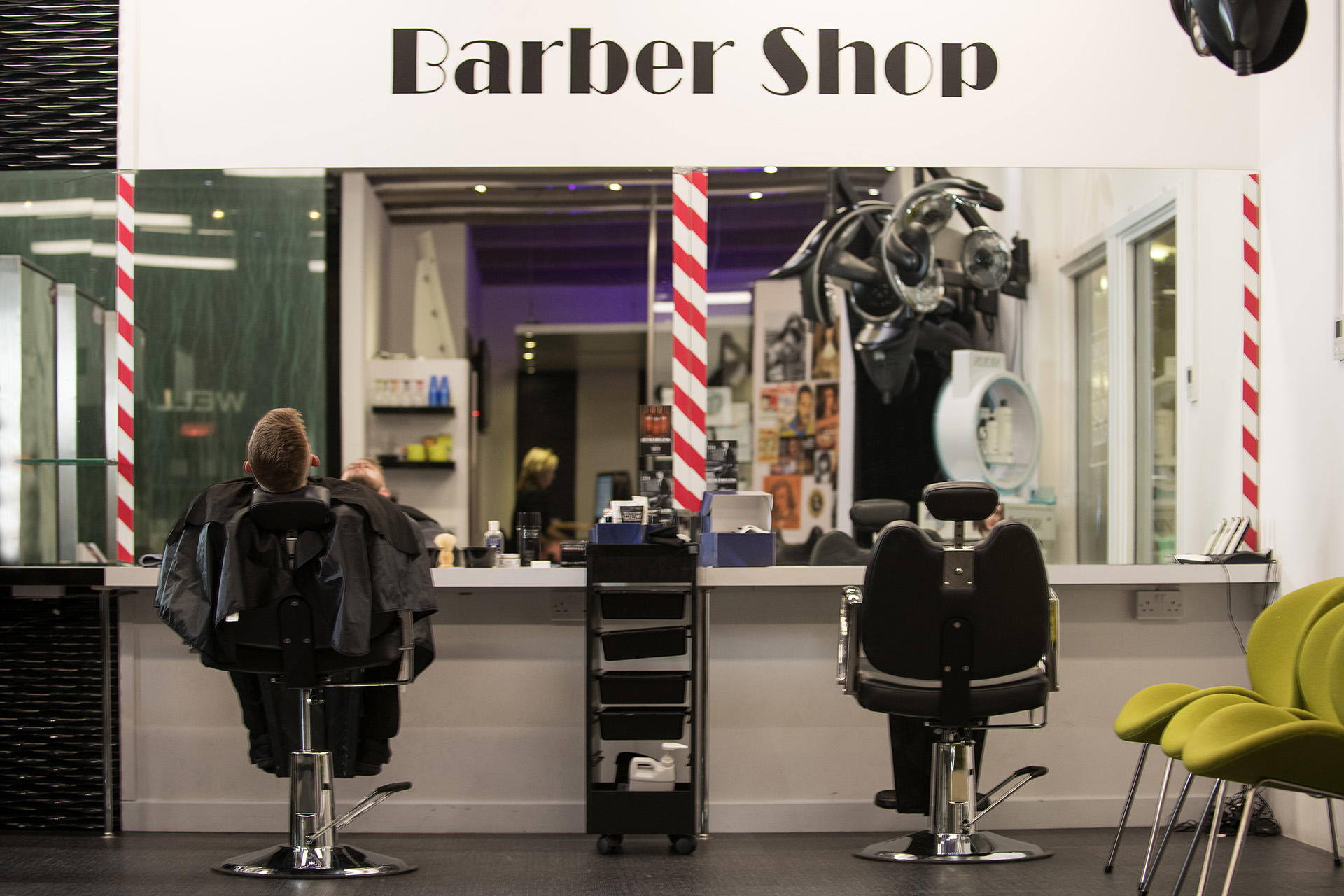 Barbershop salon at Edinburgh College, which has two chairs, storage shelves and large mirrors.